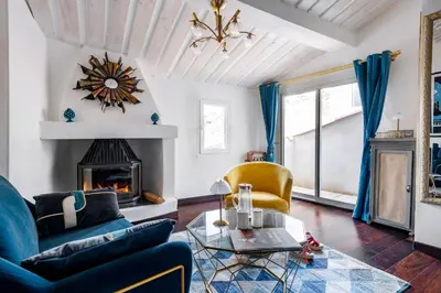 a living room with a blue couch and a fireplace at Aux Heures Bleues in LʼIsle-sur-la-Sorgue