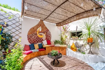 an outdoor patio with a couch and a table at Aux Heures Bleues in LʼIsle-sur-la-Sorgue