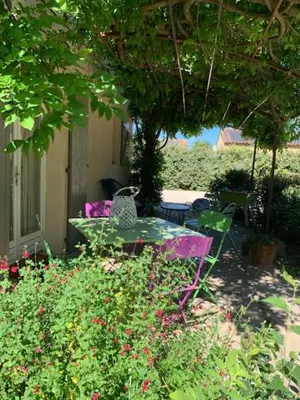 a table and chairs in a garden with flowers at La Miougrano in Plan-dʼOrgon
