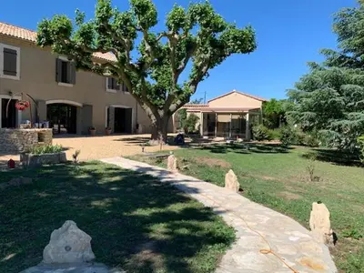 a house with a tree in front of a yard at La Miougrano in Plan-dʼOrgon