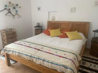 a bedroom with a large bed with yellow and orange pillows at La Miougrano in Plan-dʼOrgon