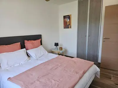 a bedroom with a large bed with pink and white pillows at Maison en Provence avec piscine in Sainte-Tulle