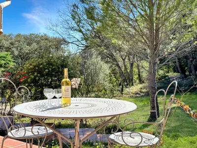 a bottle of wine sitting on a table with two wine glasses at Villa Edelweiss in Lauris