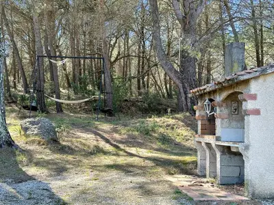 an outdoor play area with a basketball hoop in the woods at Villa Edelweiss in Lauris