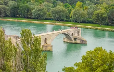 a group of people crossing a bridge over a river at Nice Home In Entraigues-Sur-La-Sorg in Entraigues-sur-la-Sorgue