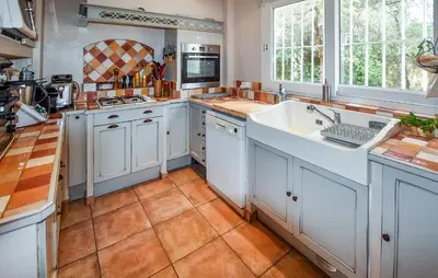 a kitchen with white cabinets and a sink at Nice Home In Entraigues-Sur-La-Sorg in Entraigues-sur-la-Sorgue