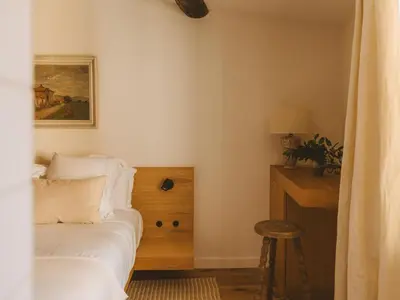 a bedroom with a bed and a desk with a painting at Le Saint Hubert in Saint-Saturnin-les-Apt