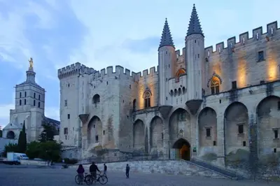 a large castle with people on bikes in front of it at Détours en Provence - Lavande 3* in Châteaurenard
