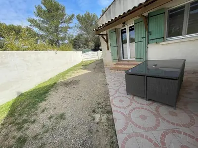 a house with a glass table outside of it at Appartement en campagne avec jardin et piscine in Grans