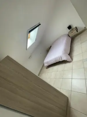 a white pillow sitting on the floor of a room at Appartement en campagne avec jardin et piscine in Grans
