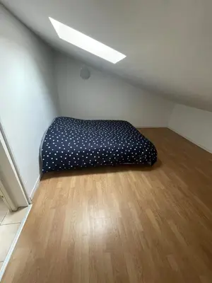 a bed in the corner of a room at Appartement en campagne avec jardin et piscine in Grans