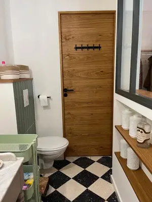 a bathroom with a toilet and a wooden door at La Grange de Paulette in Bédoin