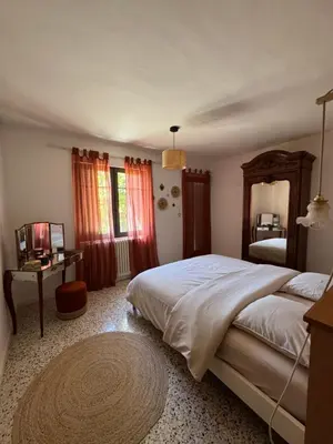 a bedroom with a large bed and a mirror at La Grange de Paulette in Bédoin