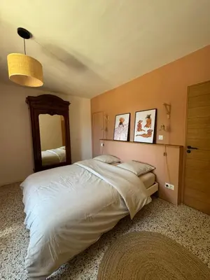 a bedroom with a large bed and a mirror at La Grange de Paulette in Bédoin