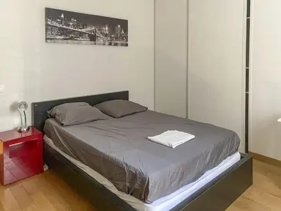 a bed in a bedroom with a red night stand at Le Jardin des Chenes in Eyragues