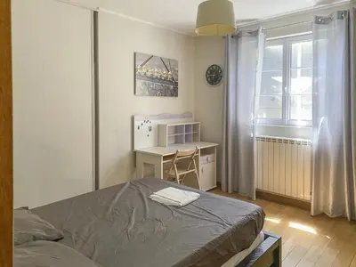 a bedroom with a bed and a desk and a window at Le Jardin des Chenes in Eyragues