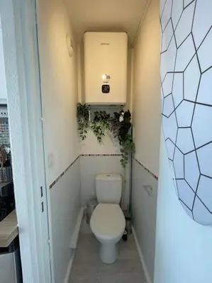 a small bathroom with a toilet and plants at Charmant Studio à 5 min d’Aix en Provence in Aix-en-Provence