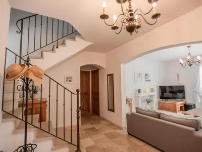 a living room with a staircase and a couch at La Cadeline in Saumane-de-Vaucluse