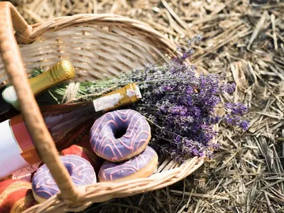 a basket with a bottle of wine and a donut and flowers at La Cadeline in Saumane-de-Vaucluse