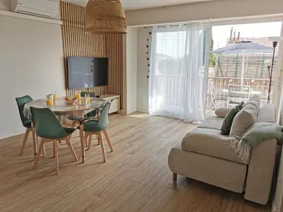 a living room with a table and a couch at Appart'Cosy - clim - terrasse - ascenseur in Cavaillon