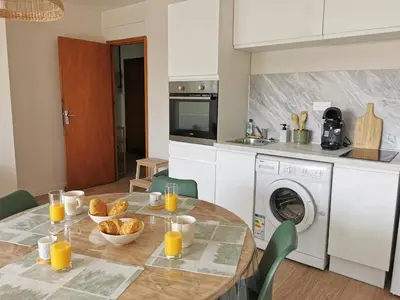 a kitchen with a table with bread and orange juice at Appart'Cosy - clim - terrasse - ascenseur in Cavaillon
