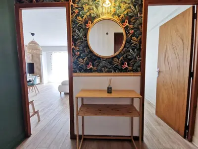 a mirror and a table in a room at Appart'Cosy - clim - terrasse - ascenseur in Cavaillon