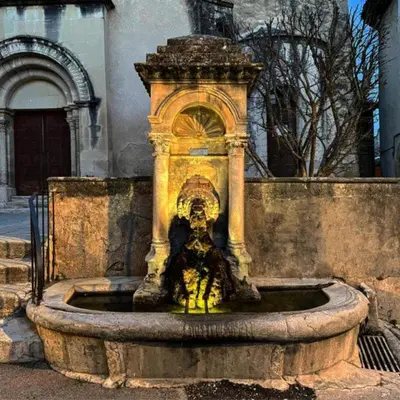 a water fountain in front of a building at Maison de charme à Lourmarin in Lourmarin