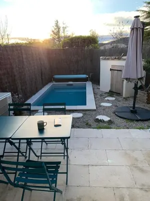 a patio with a table and chairs and a swimming pool at Maison de charme à Lourmarin in Lourmarin