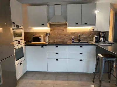 a kitchen with white cabinets and white appliances at Beau Duplex climatisé T3 vue panoramique Luberon in Pertuis