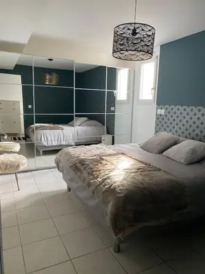 a bedroom with two beds and a large mirror at Beau Duplex climatisé T3 vue panoramique Luberon in Pertuis
