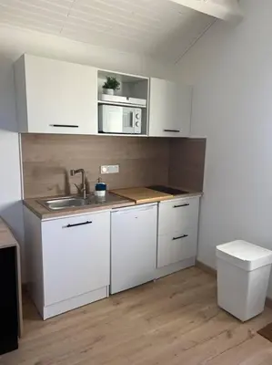 a kitchen with white cabinets and a sink at Spacieux studio 2 à 3 personnes au pied du Ventoux km Zéro in Bédoin