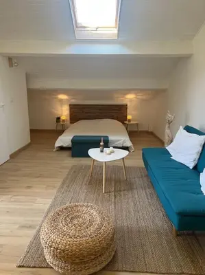 a bedroom with a bed and a couch and a table at Spacieux studio 2 à 3 personnes au pied du Ventoux km Zéro in Bédoin