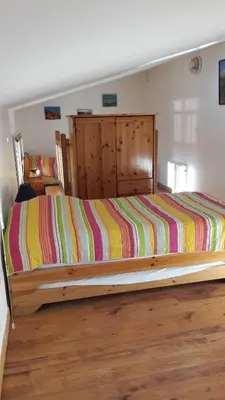 a bedroom with a bed with a colorful striped comforter at Le Pas des Lanciers in Mallemort