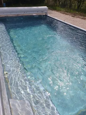 a pool of clear blue water in a backyard at Chambre dans Petit havre de paix avec piscine chauffée au coeur du Luberon in Gargas
