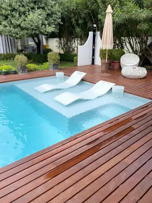 a swimming pool with a table and an umbrella at Maison AdriAnna in Vedène