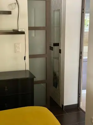 a room with a bed and a desk and a glass shower at Maison AdriAnna in Vedène