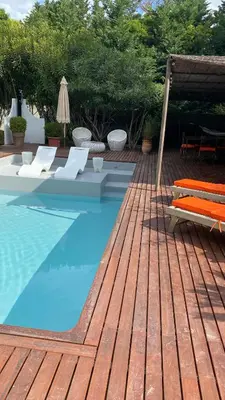 a swimming pool with chairs and a table next to at Maison AdriAnna in Vedène
