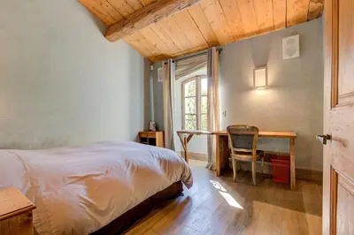 a bedroom with a bed and a desk and a window at Villa élégante à Lambesc avec spa in Lambesc