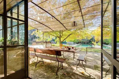 a screened in porch with a bench and a table at Villa élégante à Lambesc avec spa in Lambesc