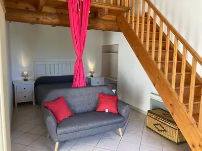 a living room with a couch and a staircase at Maison au Colorado Provençal in Rustrel