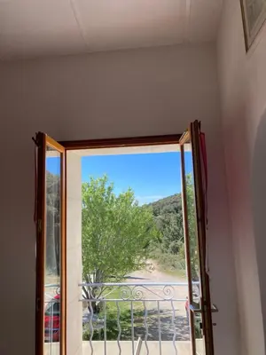 a sliding glass door with a view of a tree at Maison au Colorado Provençal in Rustrel
