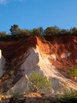 a dirt hill with trees on top of it at Maison au Colorado Provençal in Rustrel