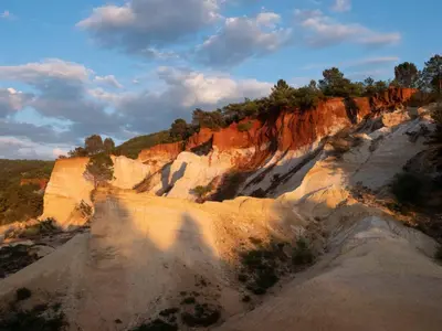 a view of a rocky cliff with trees on it at Maison au Colorado Provençal in Rustrel