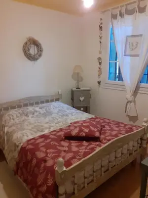 a bedroom with a bed with a red blanket and a window at Gite Bienvenue Lili in Châteauneuf-de-Gadagne