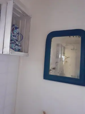 a mirror hanging on a wall next to a window at Gite Bienvenue Lili in Châteauneuf-de-Gadagne