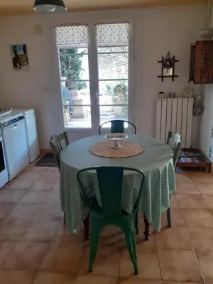 a dining room table with a green table and chairs at Gite Bienvenue Lili in Châteauneuf-de-Gadagne