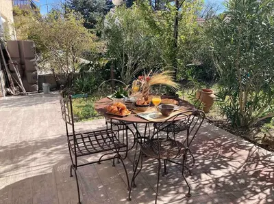 a table with two chairs and a table with food on it at Le charme de Landra in Pernes-les-Fontaines