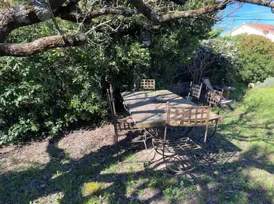 a bench sitting under a tree in a yard at Le charme de Landra in Pernes-les-Fontaines