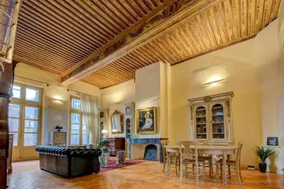 a large living room with a table and a fireplace at Maison des Arts Aix en Provence Apartment in Aix-en-Provence