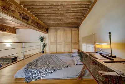 a large bed in a room with a wooden ceiling at Maison des Arts Aix en Provence Apartment in Aix-en-Provence